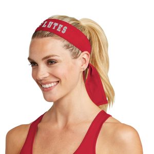 Smiling model wearing a Red Holloway Zoom Tie Back Headband with decoration that reads Flutes, front view