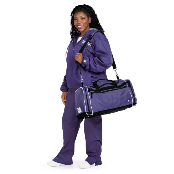 Female model holding a duffel in a Purple Champion Trailblazer Warm Up Pants with coordinating jacket, Front View