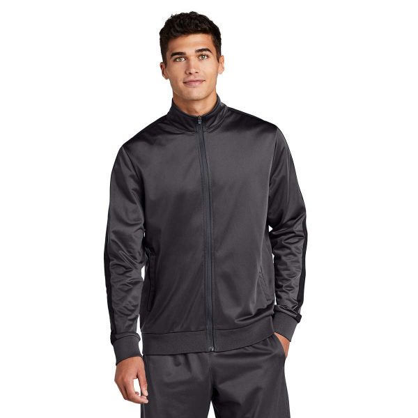 Man posing in a grey Sport-Tek Stripe Tricot Track Jacket with matching pants, front view