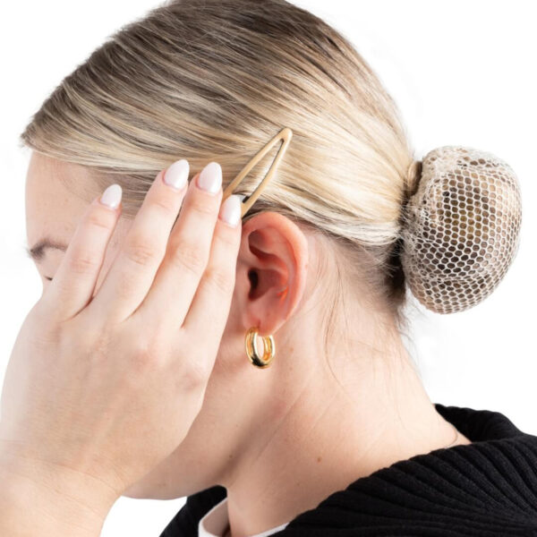 model placing a blonde Capezio Bunheads Snap Clip in her hair