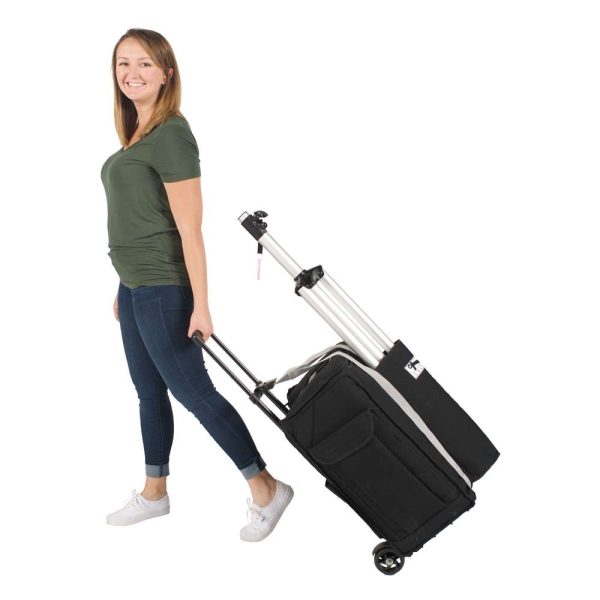woman pulling an Anchor Audio Liberty Soft Rolling Case loaded with a PA and tripod