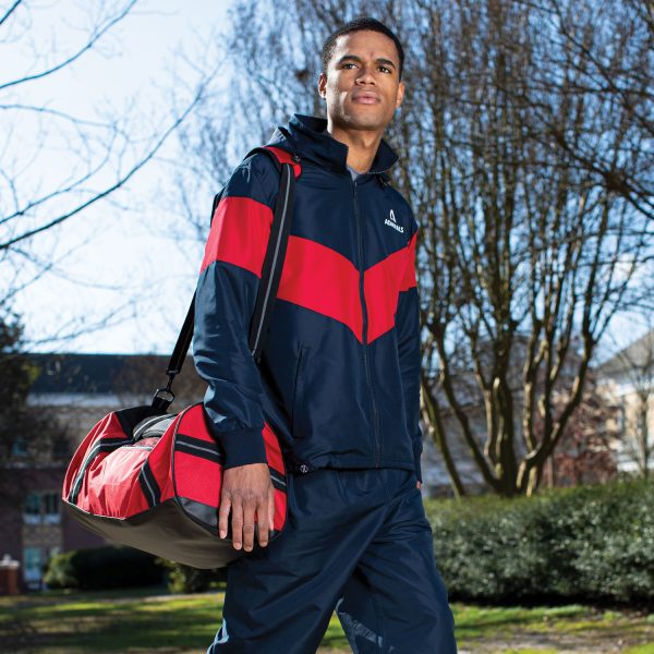 man holding a red/black Holloway Rivalry Duffel Bag on a college campus