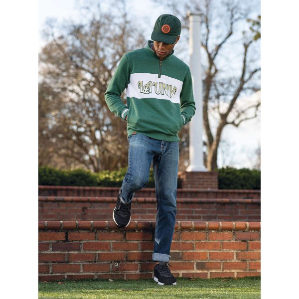 man hanging out on a campus in the evening wearing a Dark Green Heather Holloway All-American Pullover, head down