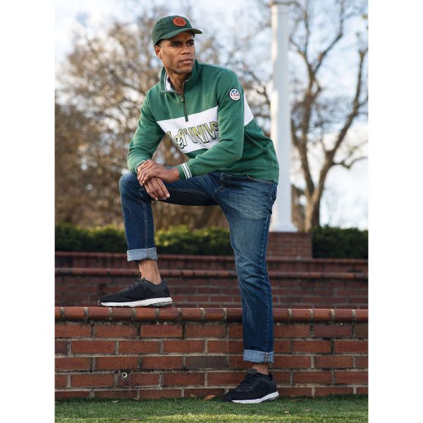 man hanging out on a campus in the evening wearing a Dark Green Heather Holloway All-American Pullover