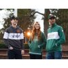 three people hanging out on a campus in the evening, one wearing a Dark Green Heather Holloway All-American Pullover